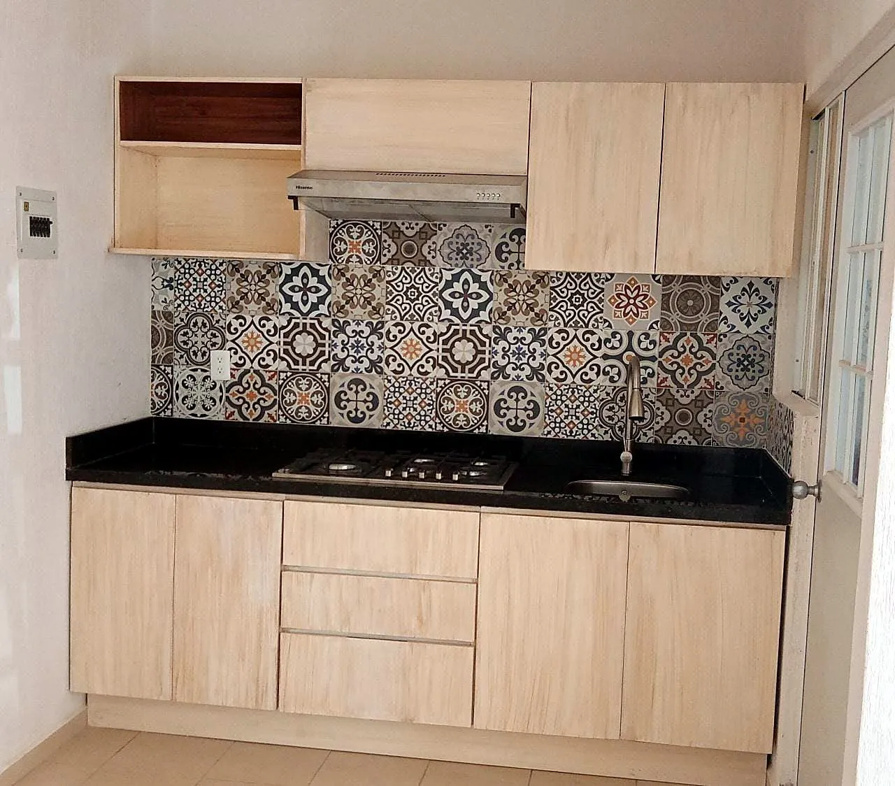 Cocina con cubierta negra y azulejo